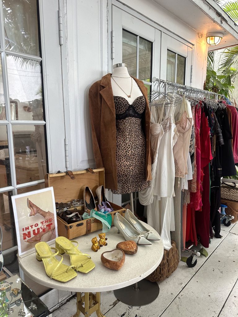 Stylish boutique display with vintage clothes, accessories, and shoes indoors.
